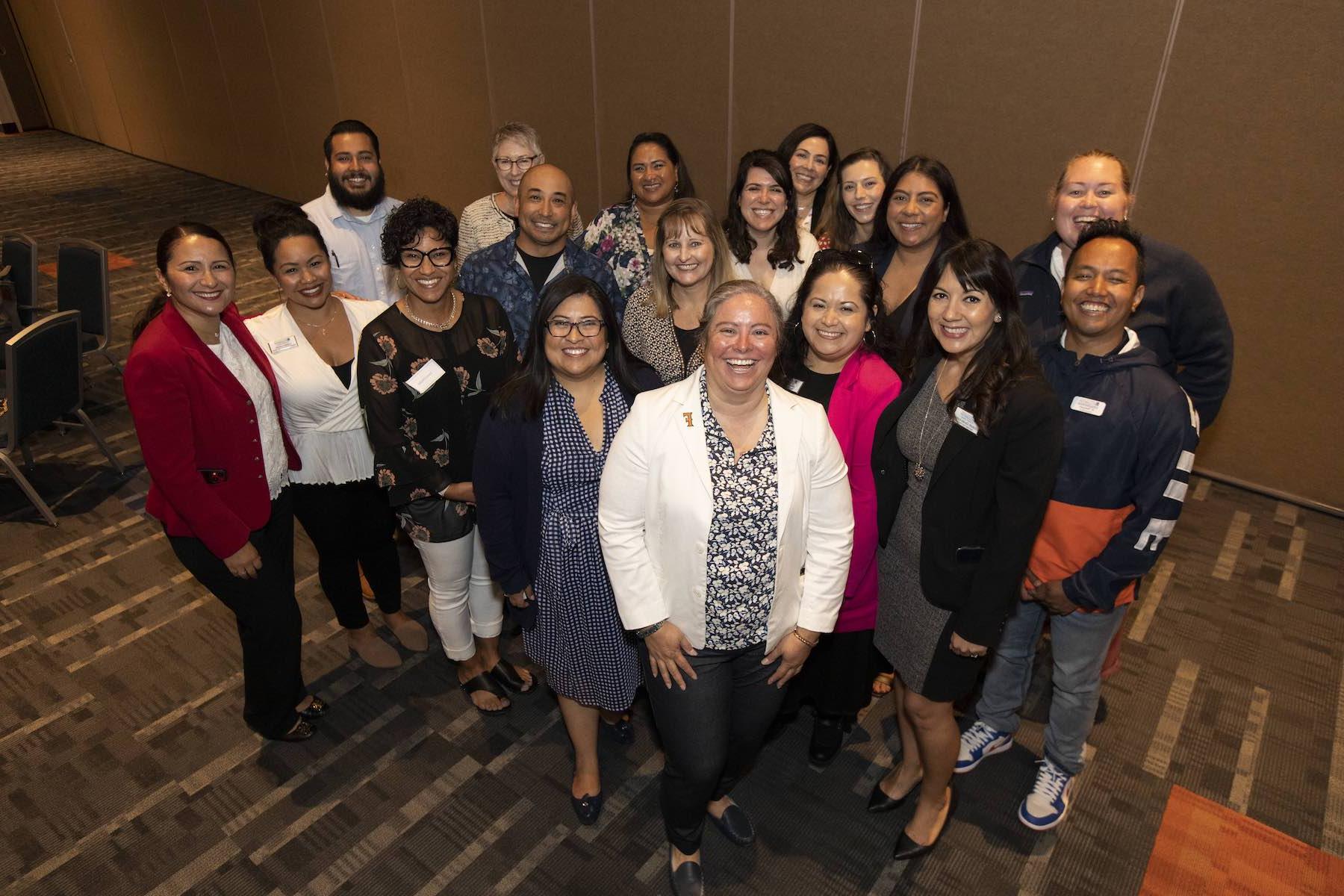 Cal State Fullerton staff alongside Santa Ana College staff pose for a picture during in an event celebration of a partnership contract between the two schools. 